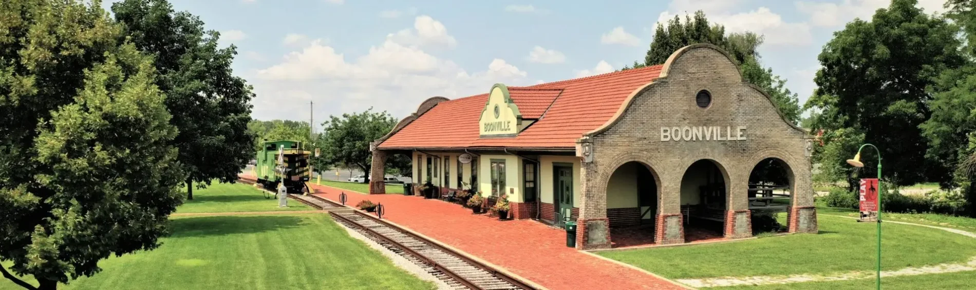 The restored Boonville Katy depot with its red tile roof, brick platform, and caboose