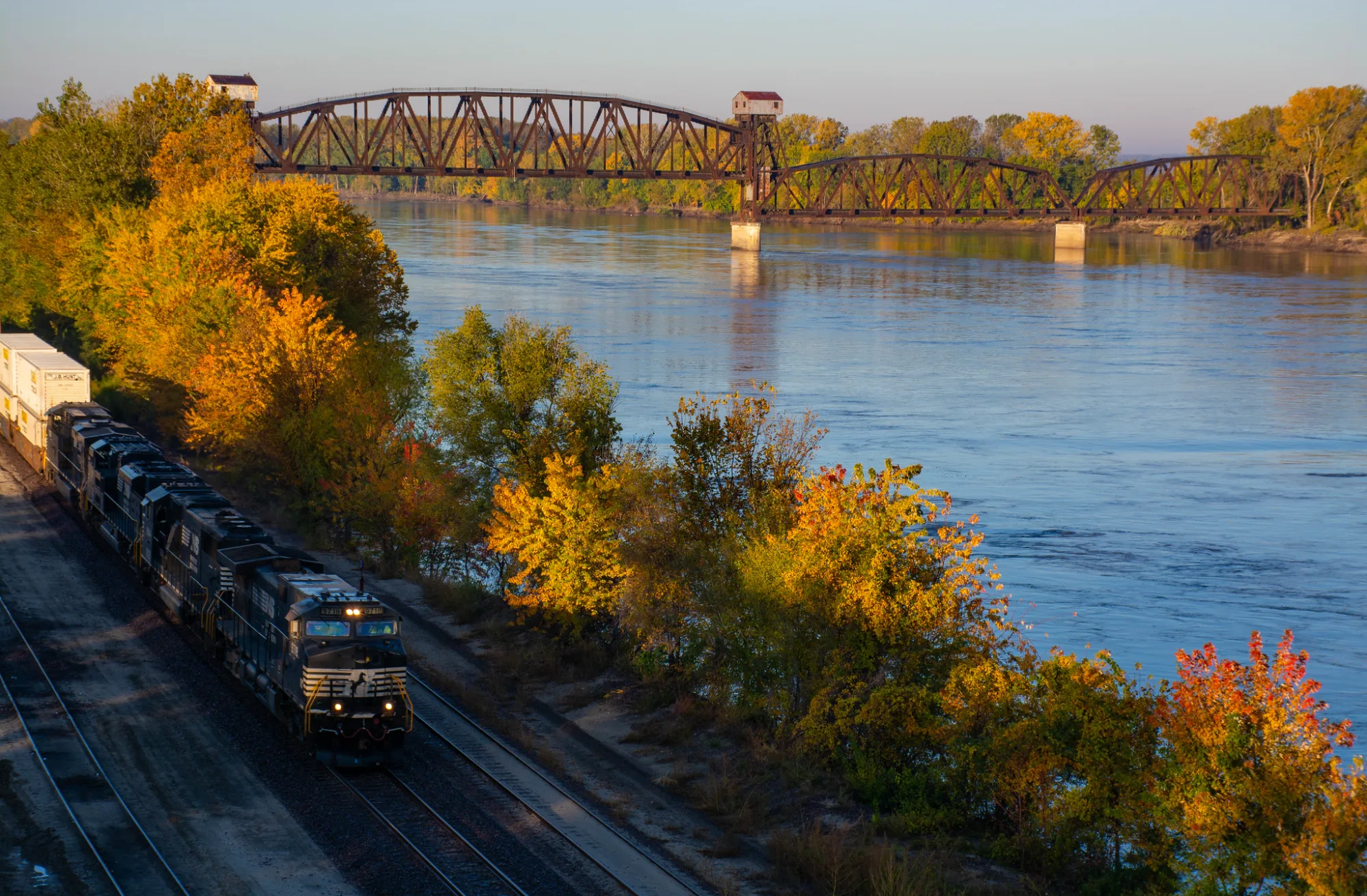 Freight train running the river bank below the Boonville Katy lift bridge in autumn